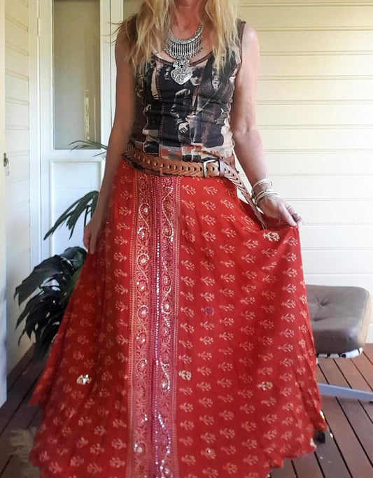 Girl wearing a band tee and orange silk sari skirt with leather belt