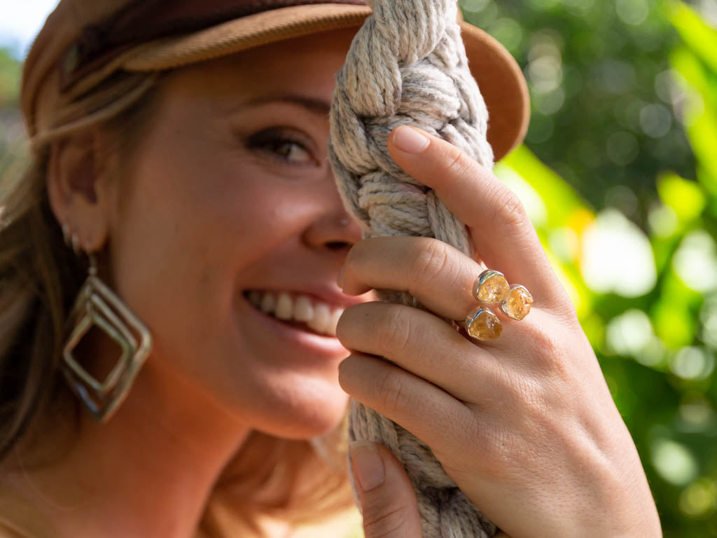 model wearing silver ring with triple set of citrine crystals.