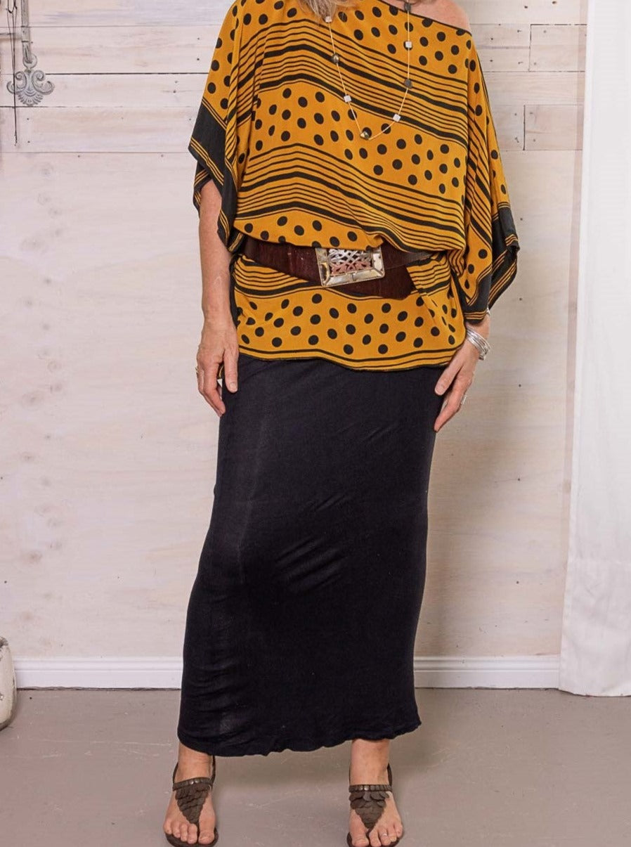 A silk kaftan in mustard and black dots with a wide belt