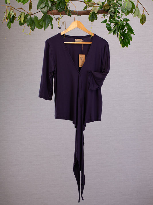 Wrap-around top has a practical mid length sleeve and a graceful neckline. The long ties fold gracefully  in the front. The colour of the soft weave material is deep purple.