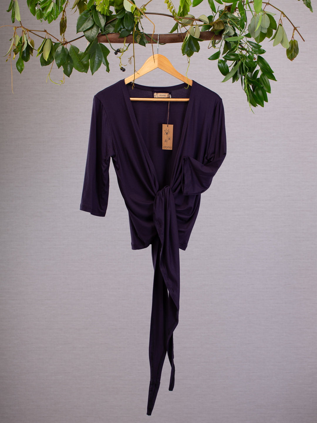 This tied-up top has a practical mid length sleeve and a graceful neckline. The long ties fold gracefully  in the front. The colour of the soft weave material is deep purple.