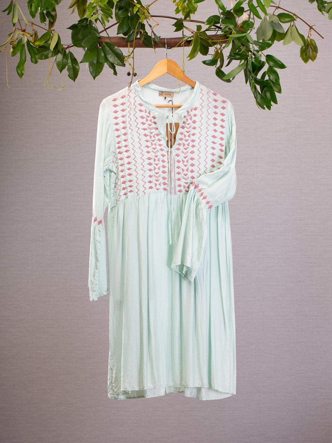 Inspired by folklore this flowing Otomo dress features a medieval styled sleeve and mauve embroidery on the chest and cuff. 