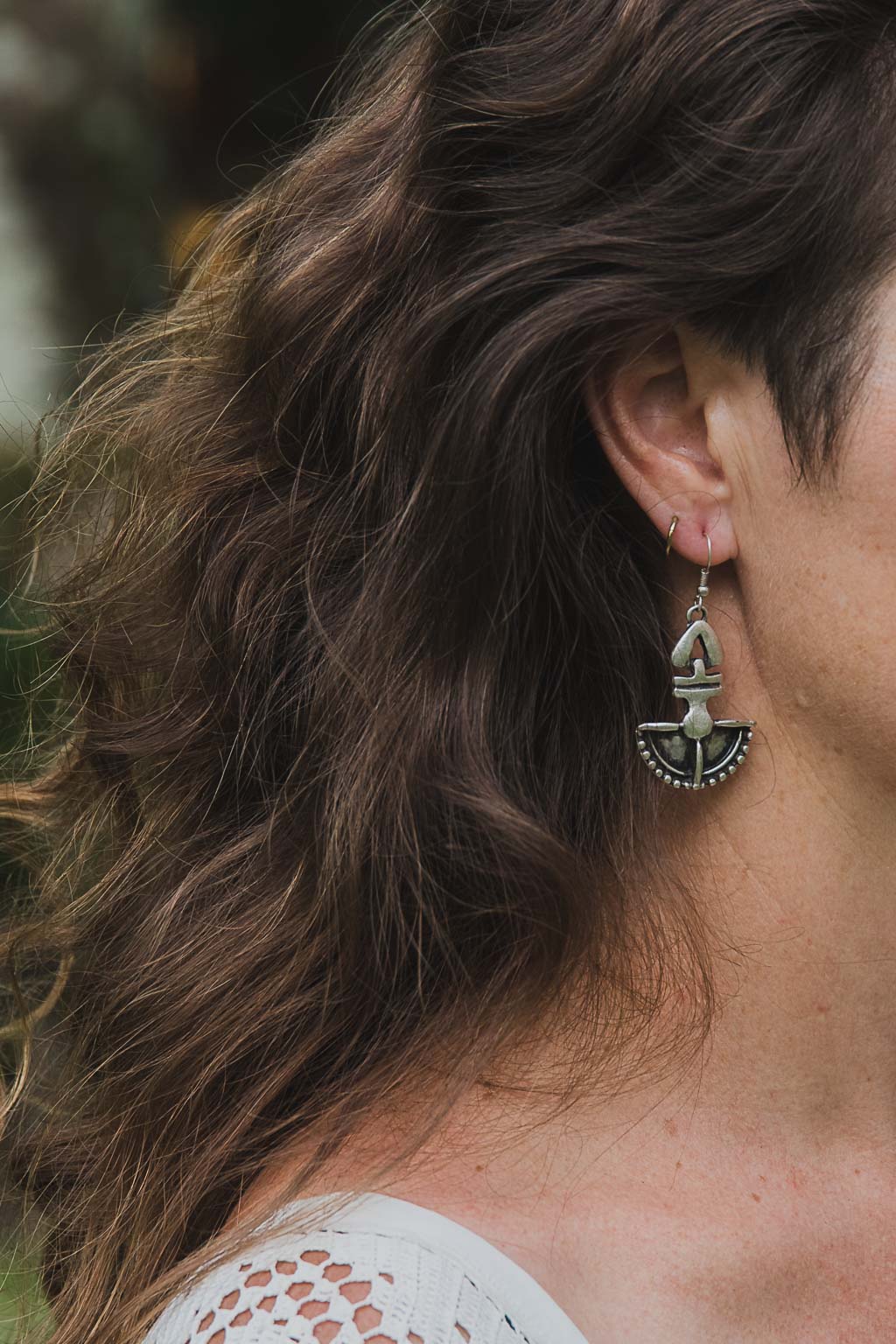 woman wear a totem styled silver hook earring