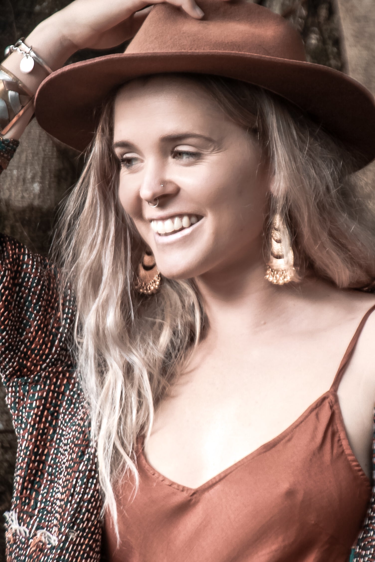 Bohemian woman with a hat and gold tassel earrings