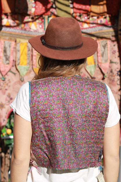 Back view of lady wearing vest with hand stitching on a purple background